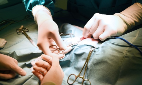 Surgeon performing surgery on patient in operating room.